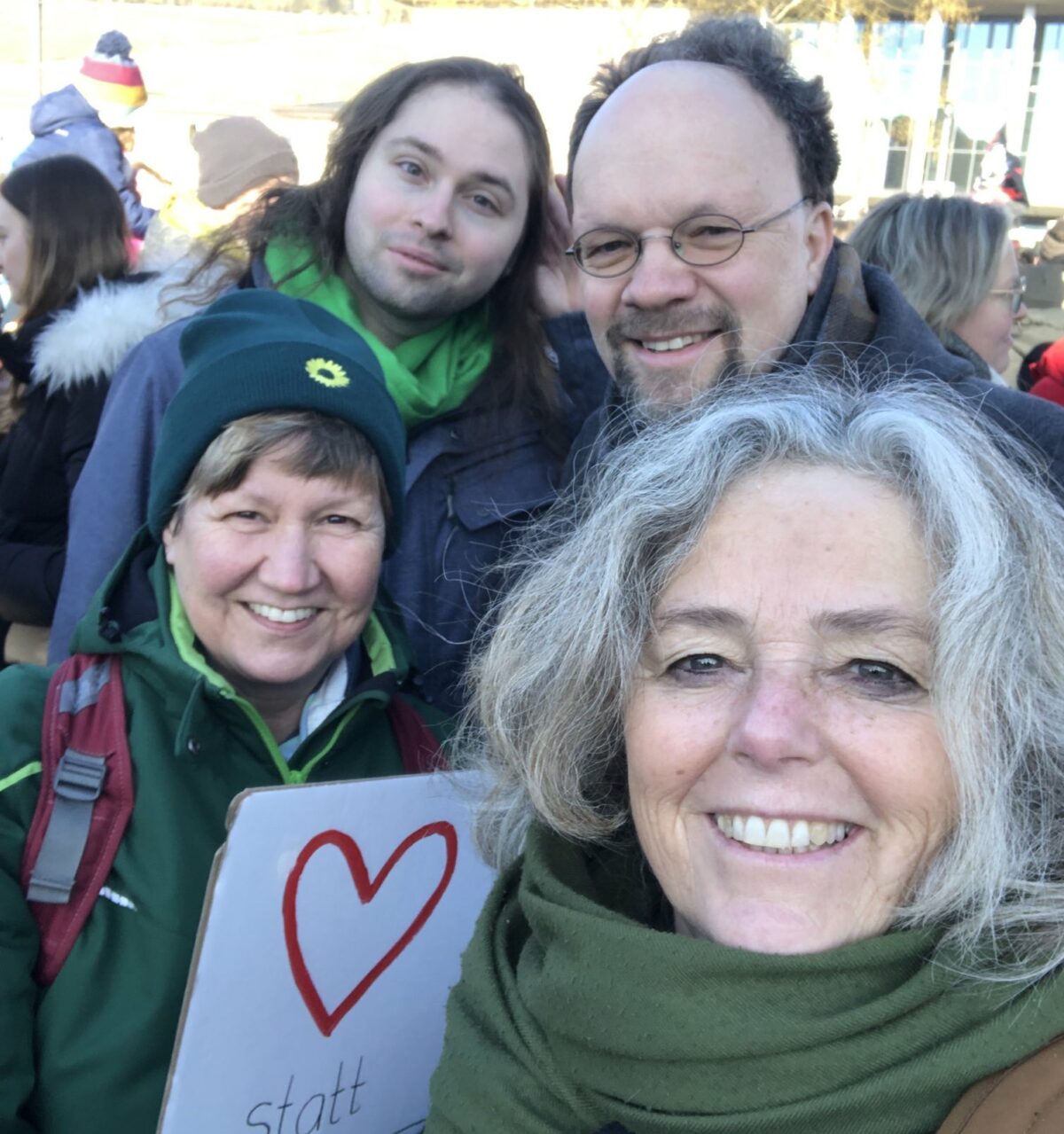 Die Grünen bei der Demo gegen Rechts. Auf dem Foto sind vier Menschen von den Grünen zu sehen. Eine hält ein weißes Schild mit einem Herz drauf