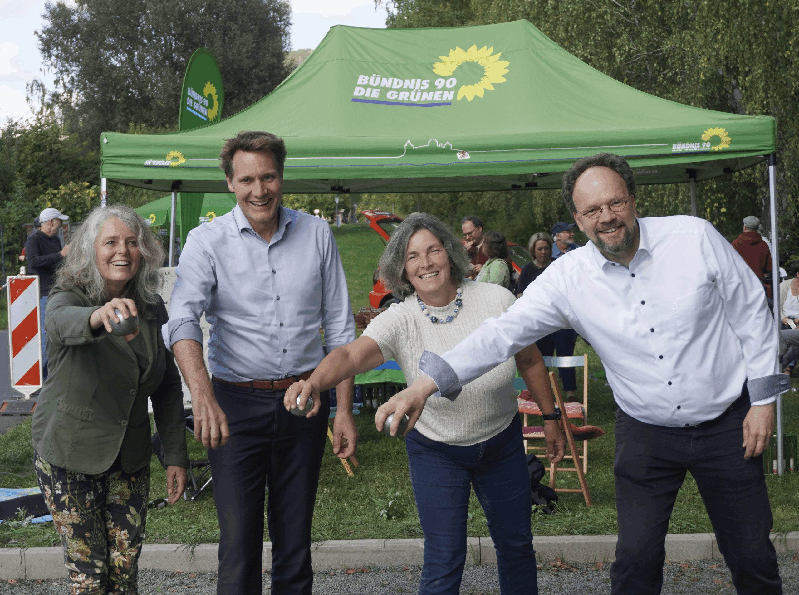 Ein Foto von Christina Feiler, Ludwig Hartmann, Kerstin Celina und Patrick Friedl, wie sie Boule Kugel in die Mitte halten.
